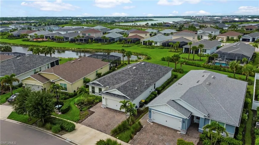Waterfront community with lush landscaping, paved driveways, and various architectural styles