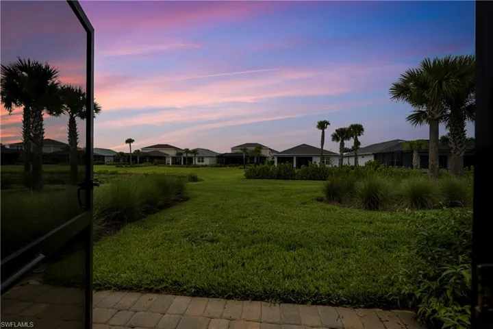 Landscaped yard featuring mature palm trees and lush greenery