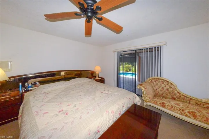 Carpeted bedroom with access to exterior and ceiling fan