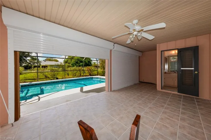 View of pool with a lanai, a patio area, and ceiling fan