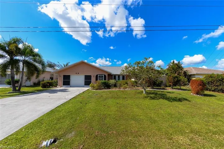 Single story home featuring a front yard and a garage