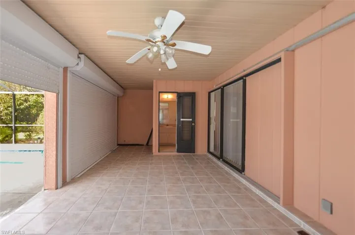 View of patio with ceiling fan and glass enclosure