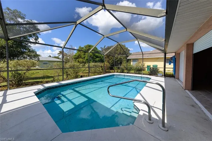 View of swimming pool with a patio and glass enclosure