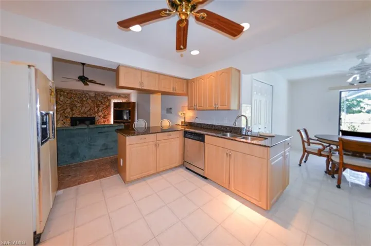 Kitchen with sink, white fridge, dishwasher, and kitchen peninsula