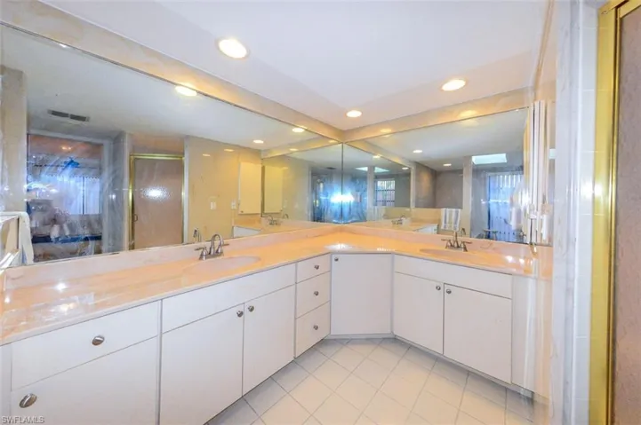 Bathroom with vanity, an enclosed shower, and tile patterned floors