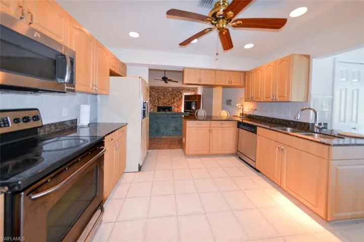 Kitchen featuring sink, light brown cabinets, kitchen peninsula, and stainless steel appliances