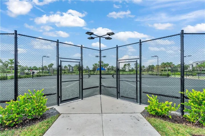 View of tennis court with a gate