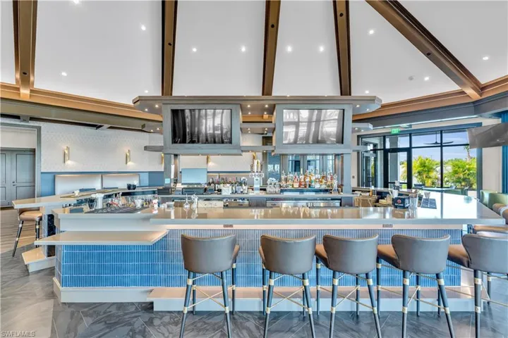Kitchen featuring light countertops, a kitchen breakfast bar, recessed lighting, and open shelves