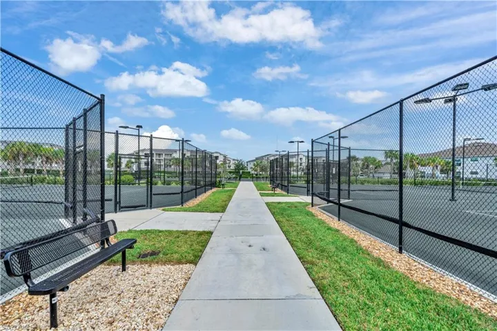View of property's community featuring a gate and a tennis court