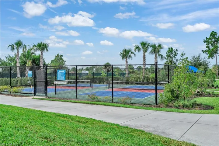 View of tennis court featuring a gate