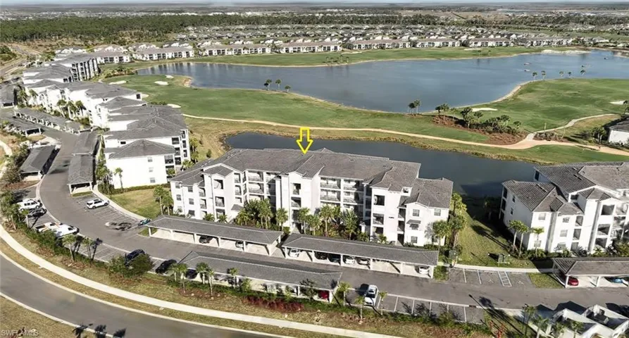 Aerial view of residential area featuring a large body of water and a local golf course