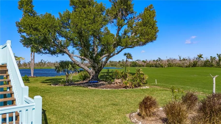 View of green lawn with a water view and golf course view