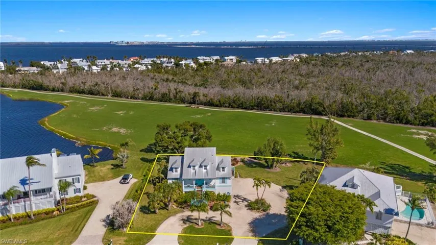 Aerial view of residential area featuring a nearby body of water and property parcel outlined