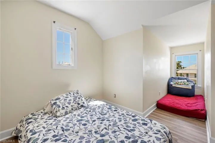 Bedroom featuring wood finished floors and vaulted ceiling