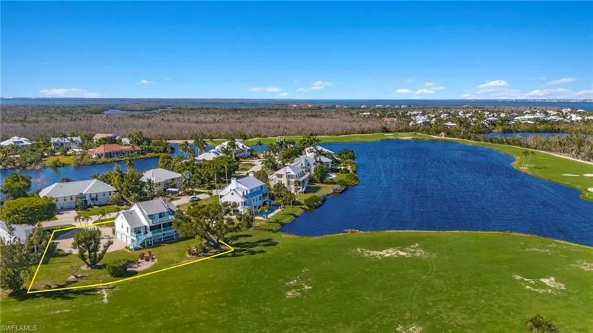 Aerial perspective of suburban area featuring a nearby body of water, property boundaries highlighted, and a golf club