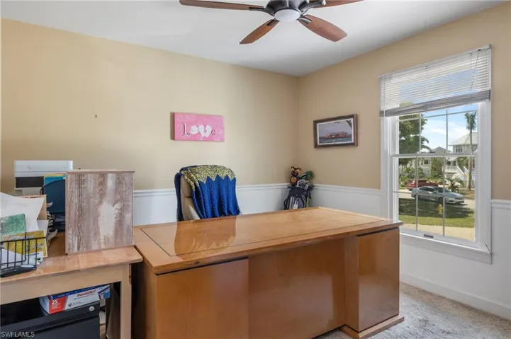 Carpeted office space featuring ceiling fan