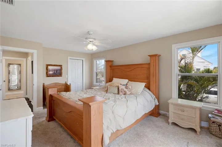 Bedroom with light colored carpet, a closet, and ceiling fan