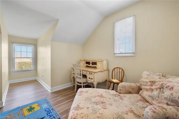 Bedroom with wood finished floors and vaulted ceiling