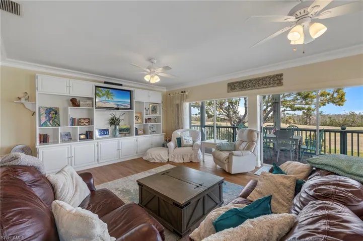 Living room featuring crown molding, a ceiling fan, and wood finished floors