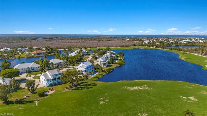 Aerial view of residential area featuring a large body of water and a local golf course