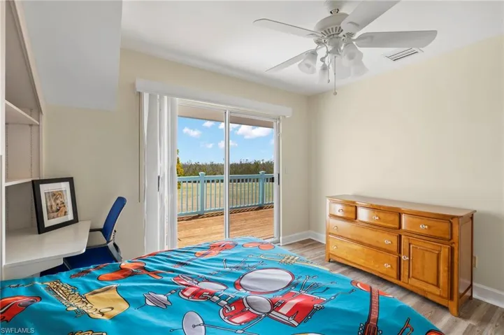 Bedroom with light wood-style flooring, access to exterior, and ceiling fan