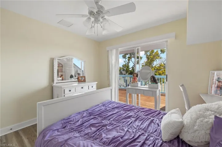 Bedroom with wood finished floors, access to exterior, and ceiling fan