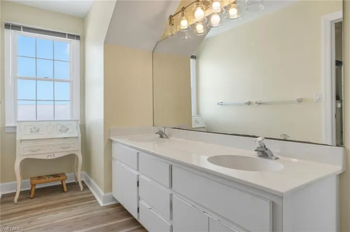 Bathroom featuring double vanity and light wood-style floors