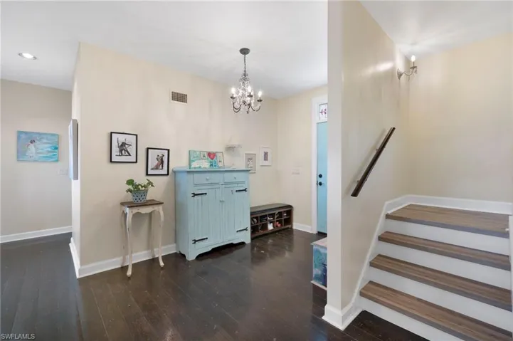 Foyer with dark wood-style flooring and a chandelier