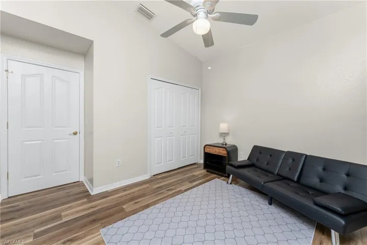 Living room with ceiling fan, lofted ceiling, and hardwood / wood-style floors