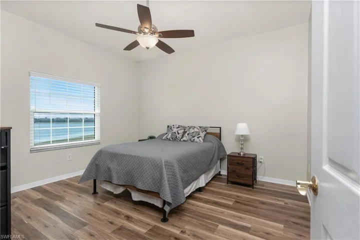 Bedroom with dark hardwood / wood-style flooring and ceiling fan