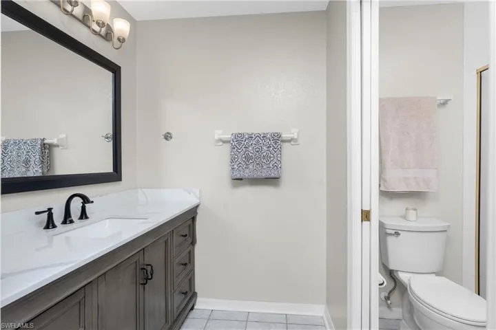 Bathroom featuring vanity, toilet, and tile patterned flooring