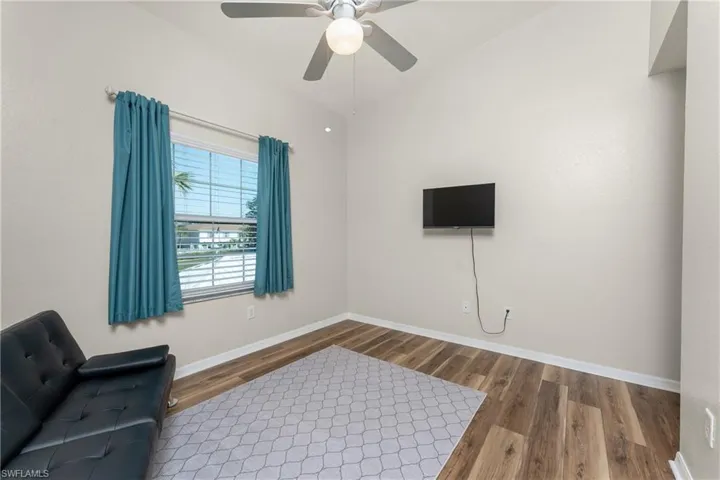 Sitting room with wood-type flooring, lofted ceiling, and ceiling fan