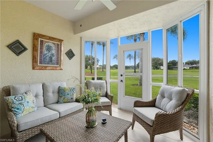 Enclosed sunroom featuring a white ceiling fan and expansive windows