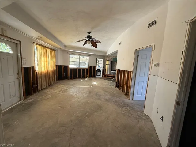 Unfurnished living room with concrete floors and ceiling fan