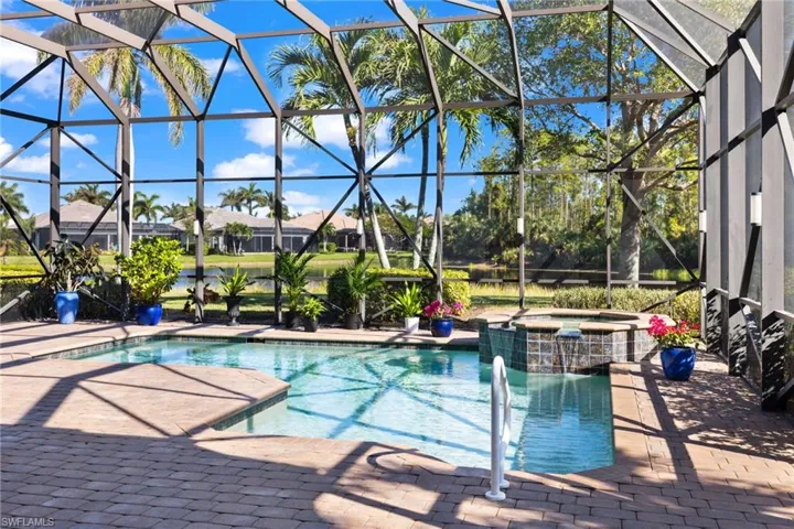 View of pool with an in ground hot tub, a patio, and a lanai