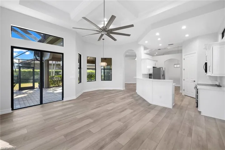 Kitchen featuring stainless steel fridge, light hardwood / wood-style floors, white cabinetry, and ceiling fan
