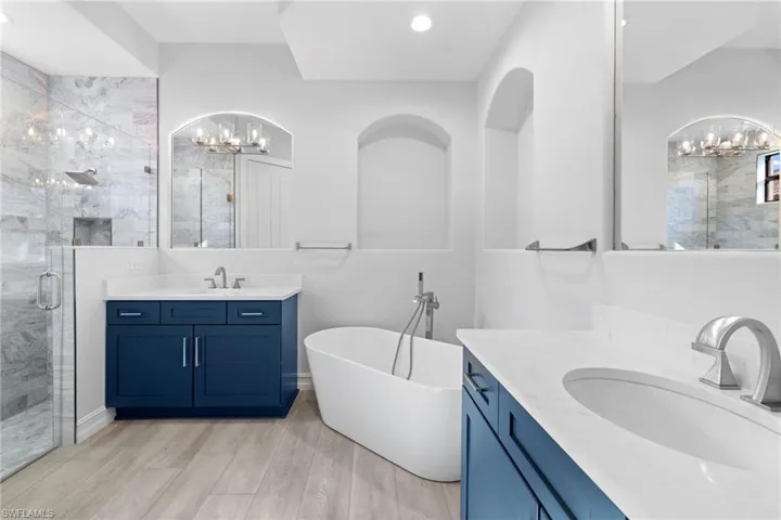 Bathroom with hardwood / wood-style flooring, vanity, and independent shower and bath