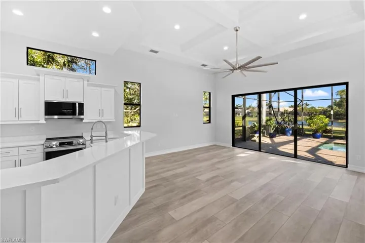 Kitchen featuring appliances with stainless steel finishes, white cabinetry, ceiling fan, and a healthy amount of sunlight