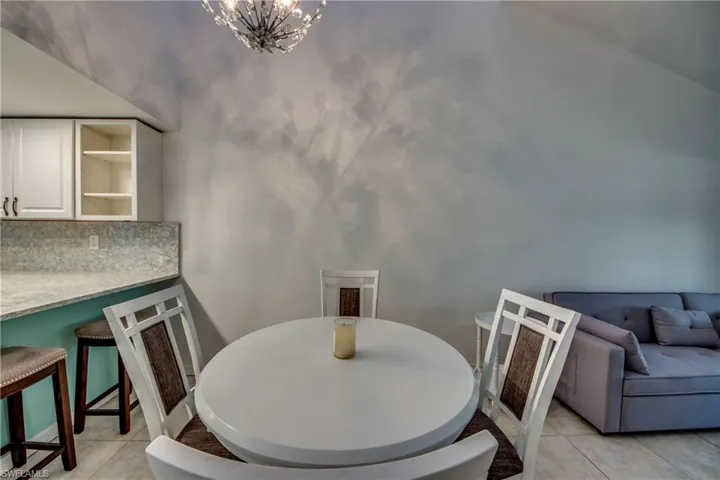 Dining room with light tile patterned flooring and a chandelier