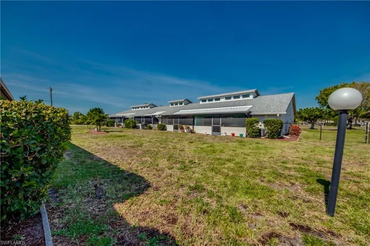 View of grassy yard featuring a sunroom