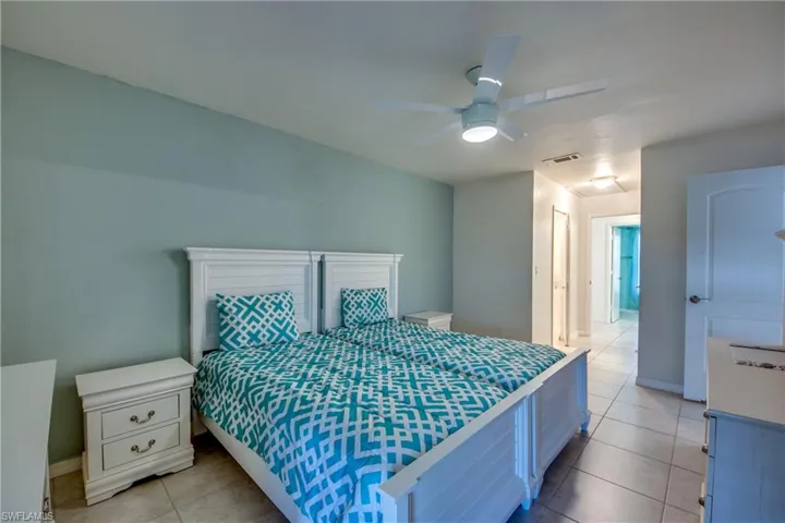 Bedroom with light tile patterned flooring, a ceiling fan, and baseboards