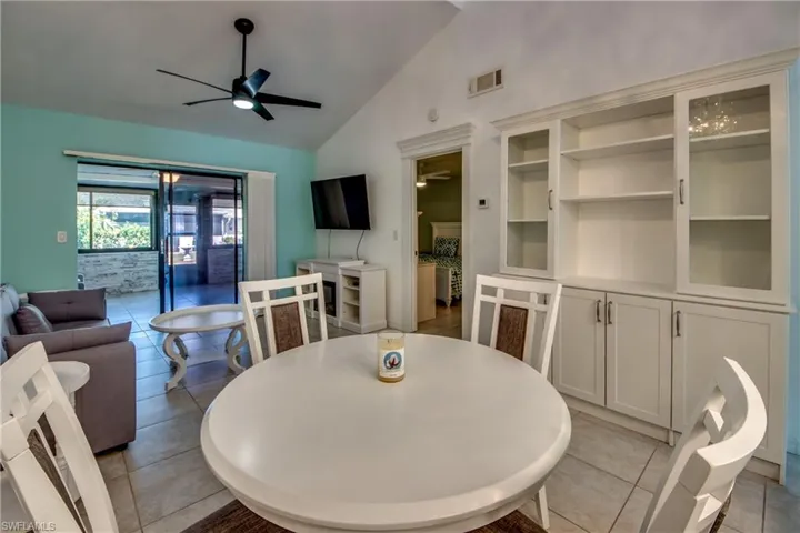 Dining space featuring a ceiling fan, vaulted ceiling, and light tile patterned floors