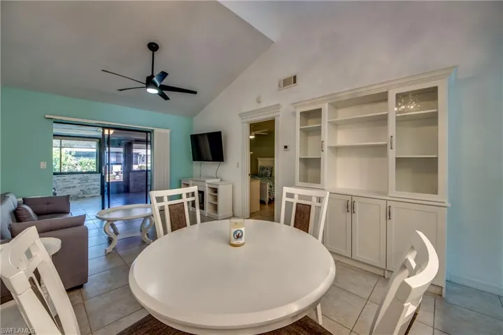 Dining space featuring a ceiling fan, light tile patterned floors, baseboards, and high vaulted ceiling