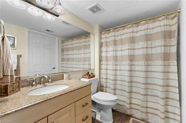 Bathroom featuring vanity, toilet, and a shower with curtain