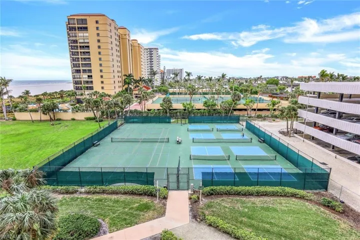 View of tennis court with a water view
