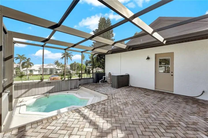 View of pool with a patio area, a jacuzzi, and glass enclosure