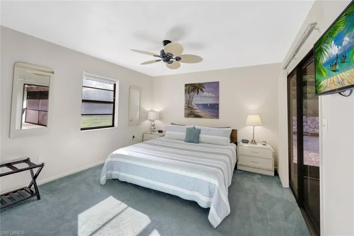 Carpeted bedroom featuring ceiling fan