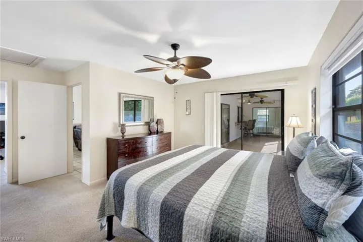 Bedroom with light colored carpet, a closet, and ceiling fan
