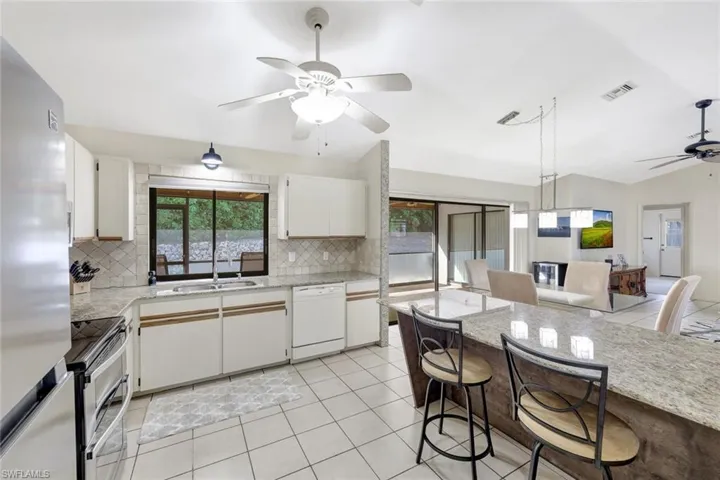 Kitchen featuring ceiling fan, sink, tasteful backsplash, and stainless steel appliances