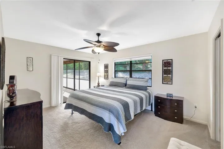 Carpeted bedroom featuring access to outside and ceiling fan
